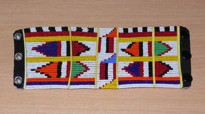 Manchette africaine perlée à motifs ethniques Massai composée de plusieurs rangs de perles de rocaille multicolores glissées sur des fils de fer fixés sur des charnières en plastique.