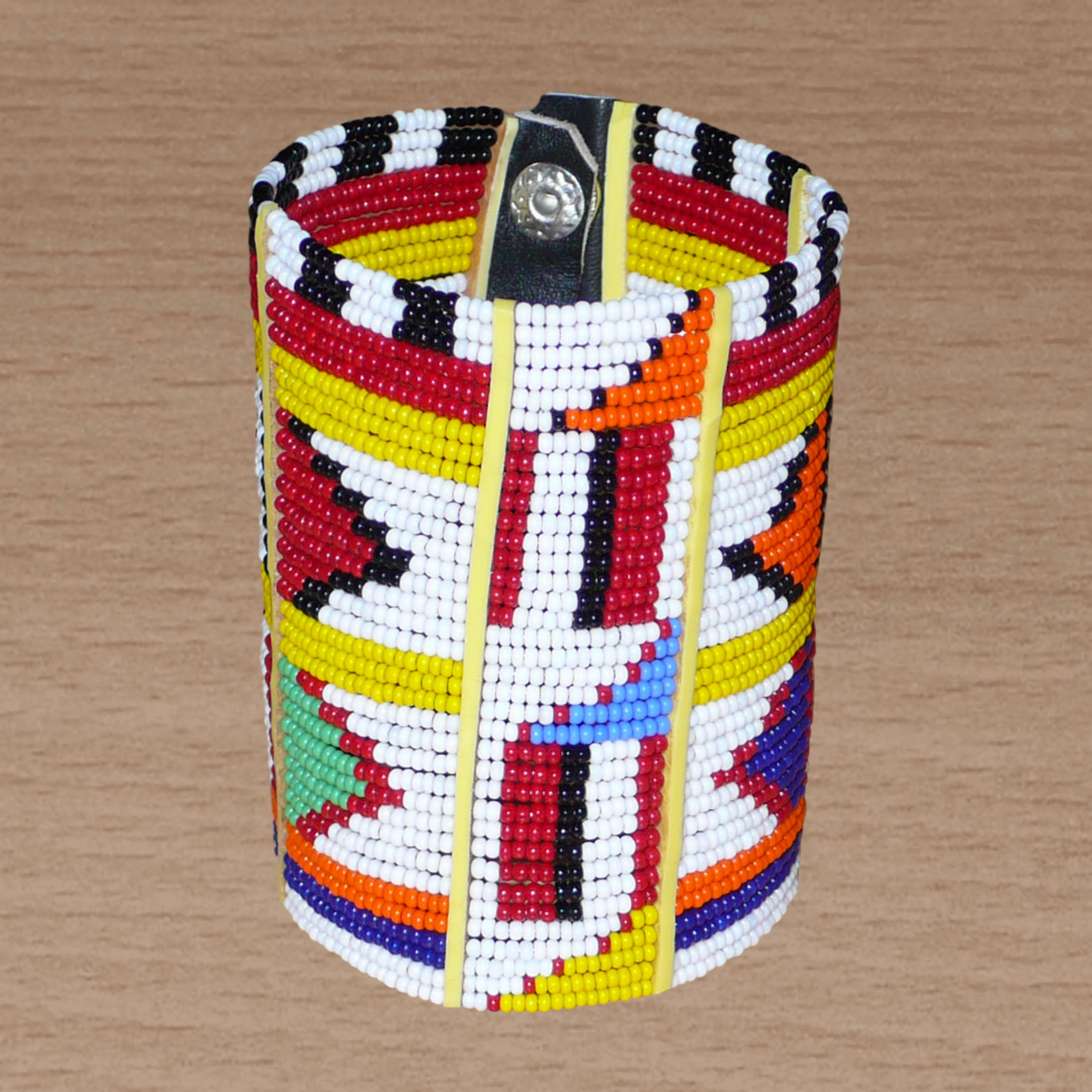 Manchette africaine perlée à motifs ethniques Massai composée de plusieurs rangs de perles de rocaille multicolores glissées sur des fils de fer fixés sur des charnières en plastique.