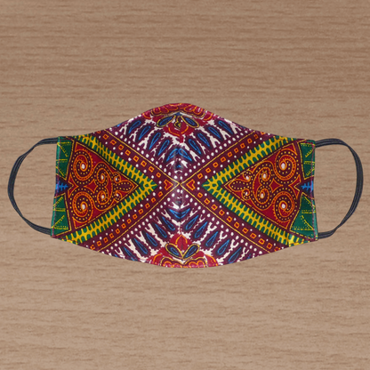 Masque textile ajusté, coupé et cousu dans un tissu africain en coton imprimé de motifs tribaux multicolores ; il se porte avec des élastiques. En vue d'une utilisation éco-responsable, ce masque est lavable et réutilisable.  Ce masque à l'allure ethnique chic mesure 21 cm de long, et 40 cm en comptant les élastiques ; il a une hauteur de 12 cm (du haut du nez jusqu'au menton) et une largeur sur les côtés de 7 cm.