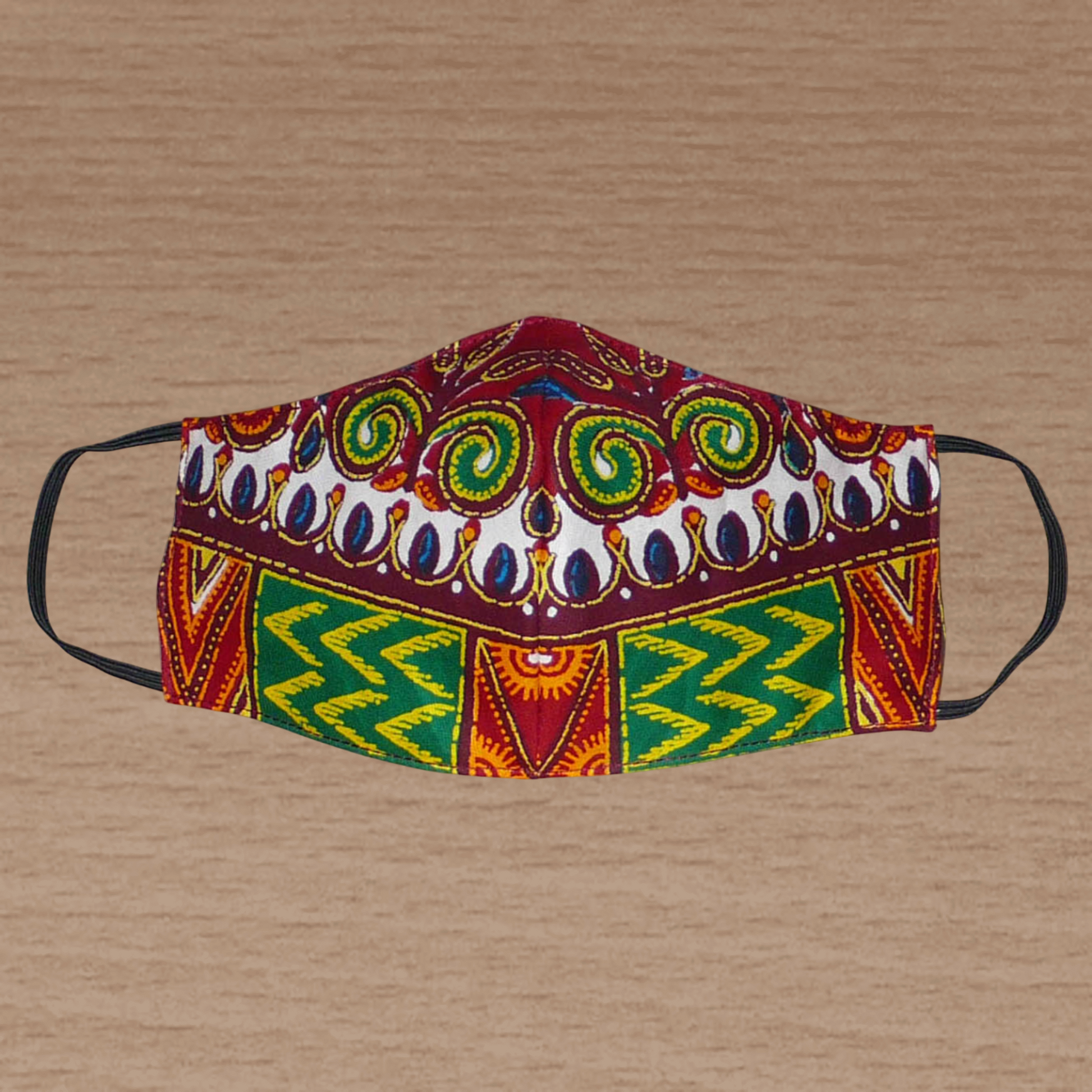 Masque textile ajusté, coupé et cousu dans un tissu africain en coton imprimé de motifs ethniques et floraux multicolores ; il se porte avec des élastiques. Fabriqué dans une démarche éco-responsable, ce masque est lavable et réutilisable.