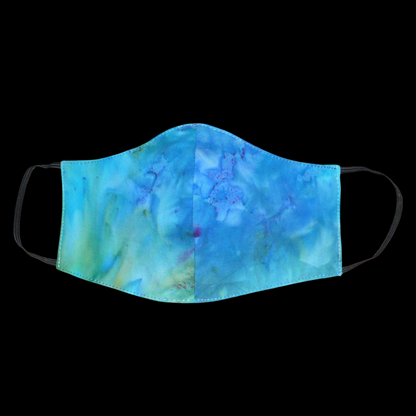 Masque facial textile à la coupe ajustée, cousu dans une cotonnade imprimée Tie and Dye bleu lagon avec des nuances de jaune et de rose ; il se porte avec des élastiques. Fabriqué en vue d'une utilisation eco-friendly, ce masque est lavable et réutilisable.