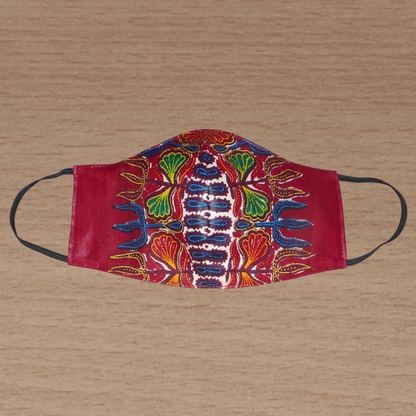 Masque facial en tissu africain bordeaux imprimé de motifs floraux à porter avec des élastiques. En vue d'une utilisation eco-responsable, il est lavable et réutilisable.