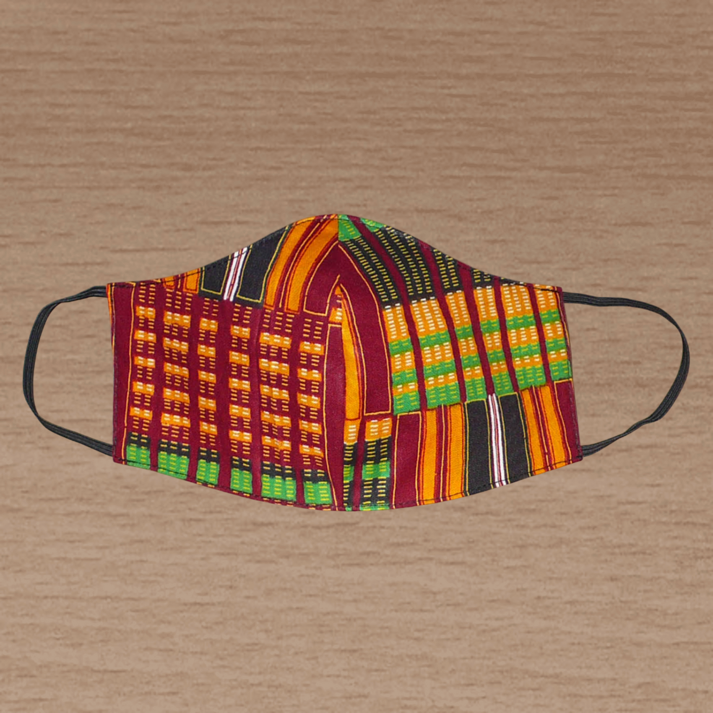 Masque facial textile pour homme en tissu africain imprimé de motifs ghanéens Kente ; il se porte avec des élastiques. En vue d'une utilisation eco-responsable, ce masque est lavable et réutilisable.