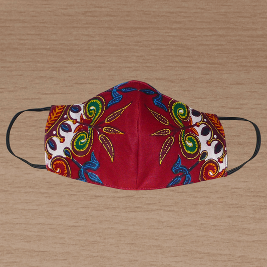 Masque facial en tissu africain bordeaux imprimé de motifs exotiques multicolores ; il se porte avec des élastiques. En vue d'un usage éco-responsable, il est lavable et réutilisable.