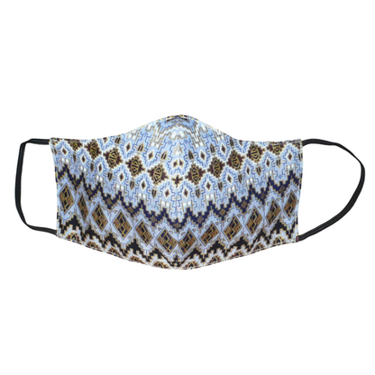 Masque facial textile à la coupe ajustée, cousu dans un tissu en coton bleu ciel à motifs ethniques bleu marine, blancs, marron et dorés ; il se porte avec des élastiques.