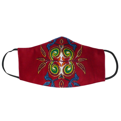 Masque en tissu africain bordeaux imprimé de motifs exotiques floraux multicolores, à porter avec des élastiques. Conçu dans l'optique d'une utilisation éco-responsable, ce masque est lavable et réutilisable.