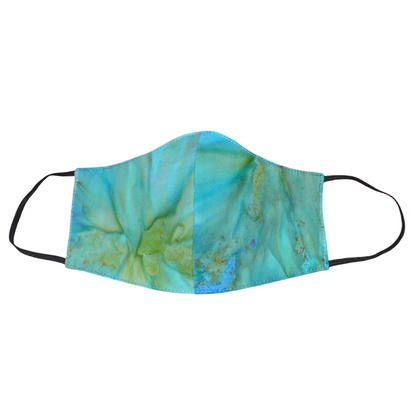 Masque facial textile en coton imprimé Tie and Dye bleu turquoise, avec des nuances de jaune et de vert ; à porter avec des élastiques.