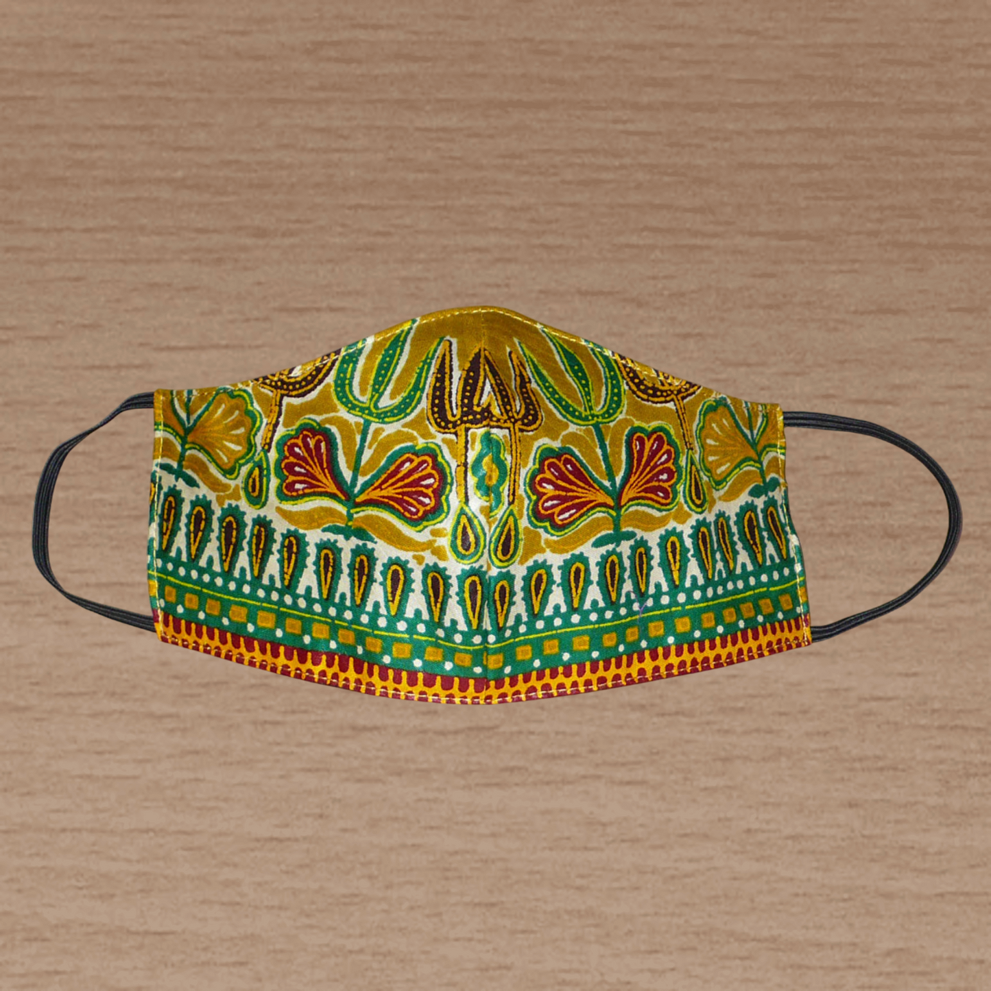 Masque en tissu africain à la coupe ajustée, coupé et cousu dans une cotonnade couleur jaune moutarde imprimée de motifs ethniques multicolores ; il s'attache avec des élastiques. En vue d'une utilisation eco-friendly, ce masque est lavable et réutilisable.  D'allure exotique, ce masque mesure 21 cm de long, et 40 cm en comptant les élastiques ; il a une hauteur de 12 cm (du haut du nez jusqu'au menton) et une largeur sur les côtés de 7 cm.  Pour des raisons évidentes d'hygiène, les retours et les échanges 