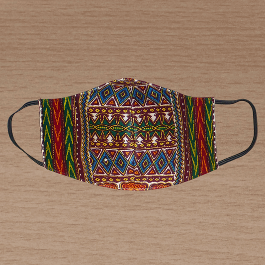 Masque textile ajusté, coupé et cousu dans un tissu africain en coton imprimé de motifs tribaux multicolores ; il se porte avec des élastiques. Fabriqué dans une approche éco-responsable, ce masque est lavable et réutilisable.