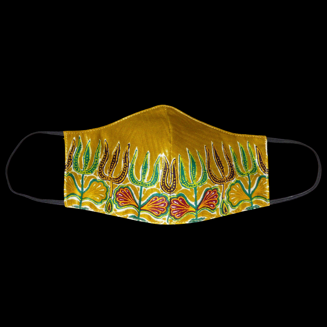 Masque facial en tissu africain en coton de couleur jaune moutarde imprimé de motifs ethniques floraux multicolores ; il se porte avec des élastiques. Fabriqué dans une démarche eco-responsable, ce masque est lavable et réutilisable.