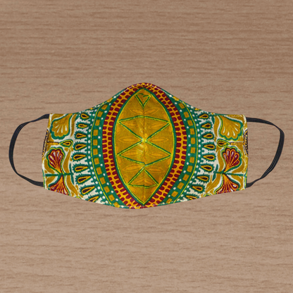 Masque facial en tissu africain jaune d'or imprimé de motifs exotiques multicolores ; il se porte avec des élastiques. En vue d'un usage éco-responsable, il est lavable et réutilisable.