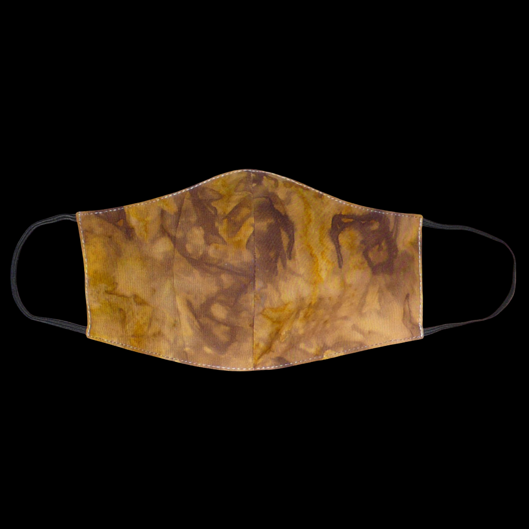 Masque textile coupé et cousu dans un tissu en coton imprimé Tie and Dye aux nuances de marron, beige et jaune ; il se porte avec des élastiques. Conçu dans une démarche eco-friendly, ce masque est lavable et réutilisable.