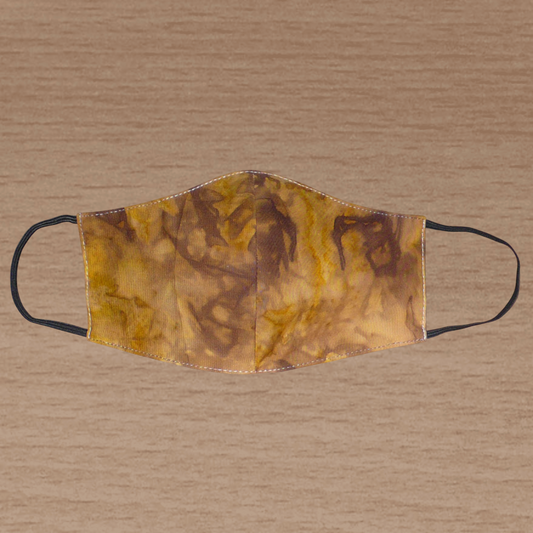 Masque textile coupé et cousu dans un tissu en coton imprimé Tie and Dye aux nuances de marron, beige et jaune ; il se porte avec des élastiques. Conçu dans une démarche eco-friendly, ce masque est lavable et réutilisable.