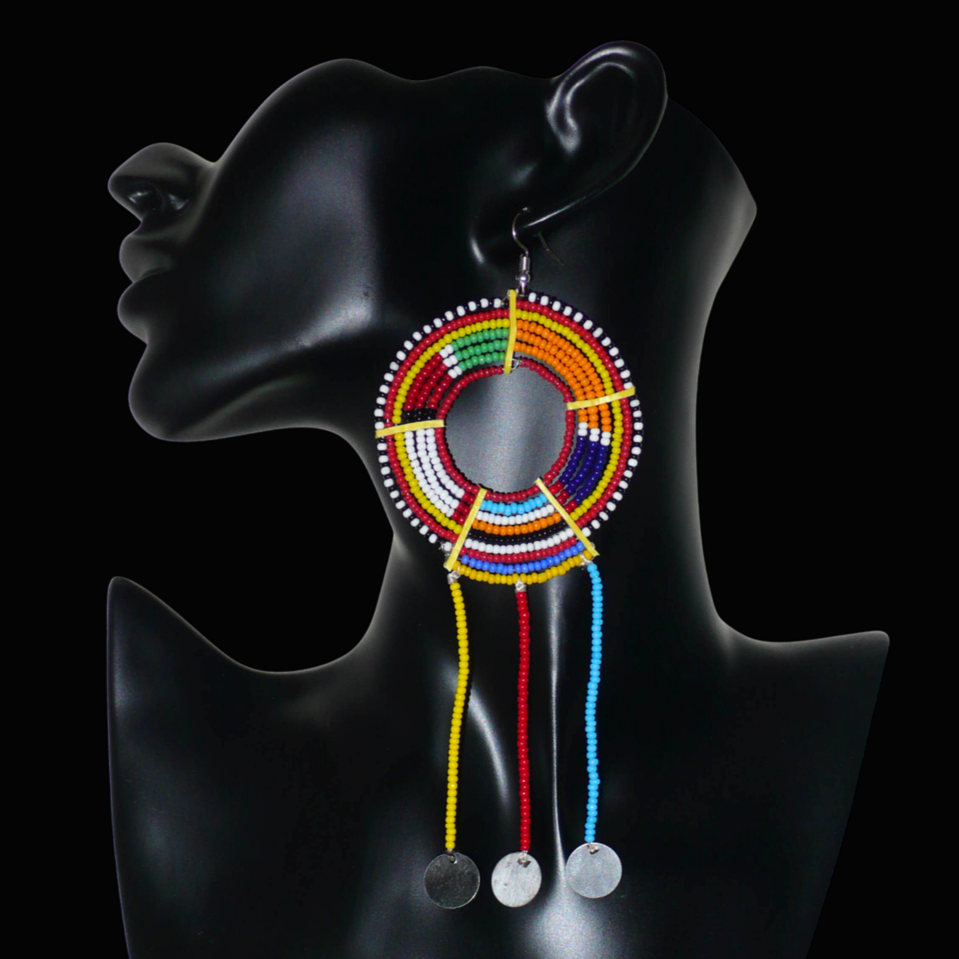 Longue mono boucle d'oreille africaine Massai à porter sur une seule oreille pour un effet visuel asymétrique. Elle se compose de perles de rocaille multicolores enfilées sur des fils de fer montés en cercles fixés sur des charnières en plastique recyclé jaune, et se prolonge de franges perlées ornées de disques en métal. Surdimensionnée, cette mono boucle d'oreille mesure 15.5 cm de long et se porte sur une oreille percée.