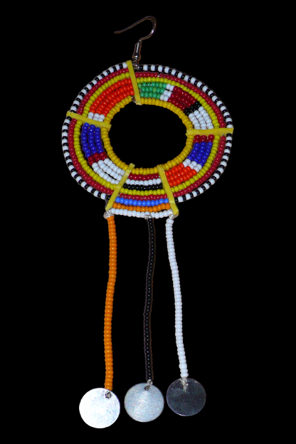 Mono boucle d'oreille confectionnée dans la plus pure tradition tribale Massai, à porter sur une seule oreille pour un effet visuel asymétrique, composée de perles de rocaille jaunes et multicolores enfilées sur des fils de fer montés en cercles et se prolonge de franges perlées ornées de disques métalliques. Surdimensionnée, elle mesure 16 cm de long et se porte sur des oreilles percées.