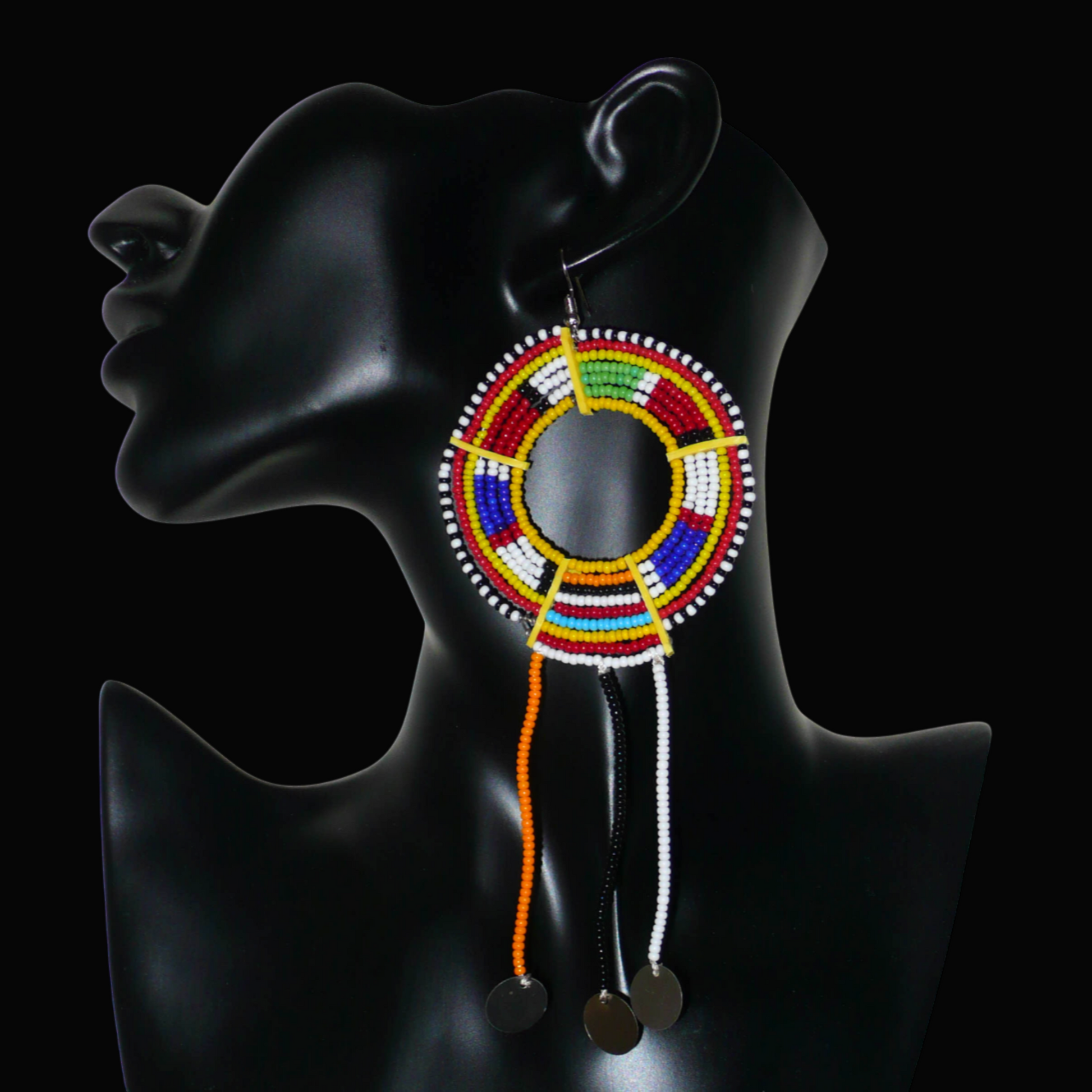 Mono boucle d'oreille à porter sur une seule oreille pour un effet visuel asymétrique : elle se compose de perles de rocaille jaunes et multicolores enfilées sur des fils de fer montés en cercles fixés sur des charnières en plastique recyclé jaune, et se prolonge de franges perlées ornées de disques métalliques. Surdimensionnée, elle mesure 16 cm de long.