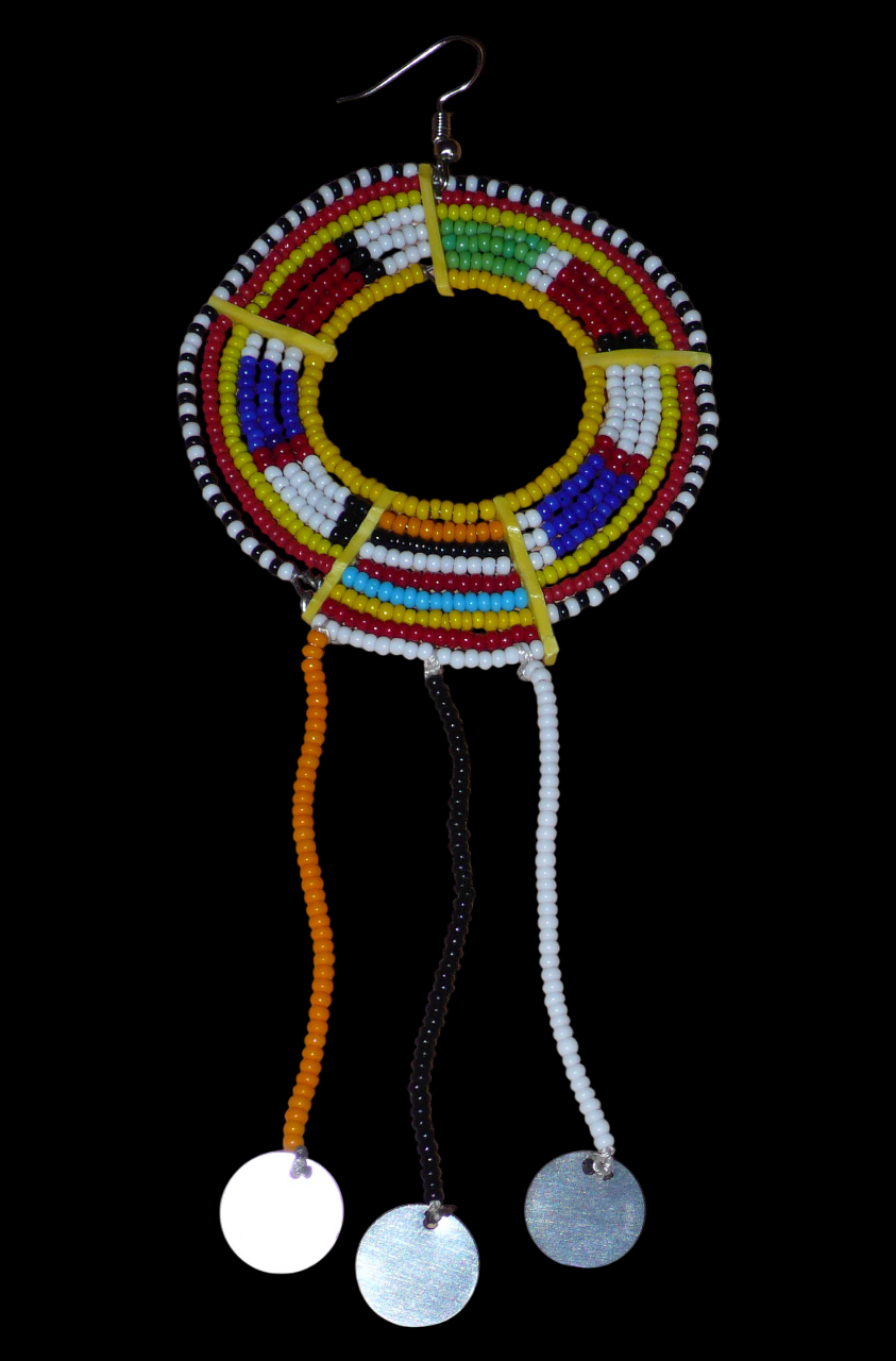 Mono boucle d'oreille à porter sur une seule oreille pour un effet visuel asymétrique : elle se compose de perles de rocaille jaunes et multicolores enfilées sur des fils de fer montés en cercles fixés sur des charnières en plastique recyclé jaune, et se prolonge de franges perlées ornées de disques métalliques. Surdimensionnée, elle mesure 16 cm de long.