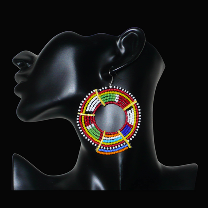 Apportez de l'éclat à votre look avec cette mono boucle africaine Massai à porter d'un seul côté pour un effet visuel asymétrique ! De fabrication traditionnelle artisanale, ce bijou exotique unique se compose de perles de rocaille rouges et multicolores glissées sur des fils de fer montés en cercles et fixés sur des charnières en plastique recyclé jaune. Surdimensionnée, elle mesure 8 cm de long, et se porte sur une oreille percée.