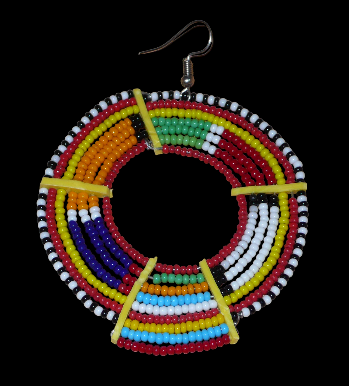Affirmez votre style afro et apportez de la couleur à votre look avec cette mono boucle africaine de tradition Massai, à porter sur une seule oreille pour un effet visuel asymétrique !  De fabrication artisanale kenyane, ce bijou unique se compose de perles de rocaille rouges et multicolores enfilées sur des fils de fer montés en cercles et fixés sur des charnières en plastique recyclé jaune. Surdimensionnée, cette mono boucle mesure 8 cm de long et se porte sur une oreille percée.
