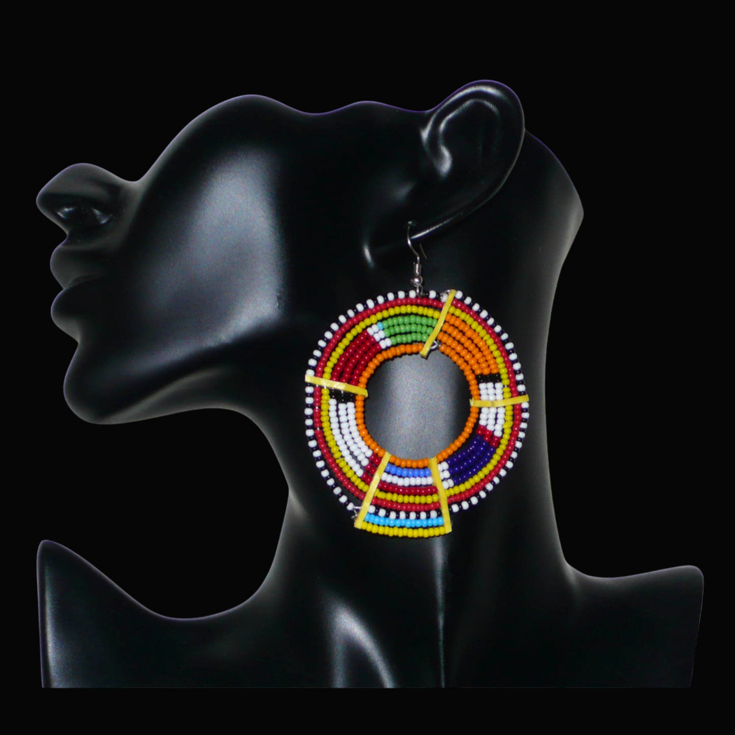 Ajoutez une touche colorée à votre look avec cette mono boucle africaine Massai, à porter d'un seul côté pour un effet visuel asymétrique ! De fabrication kenyane, ce bijou artisanal traditionnel se compose de perles de rocaille orange et multicolores glissées sur des fils de fer montés en cercles et fixés sur des charnières en plastique recyclé jaune. Surdimensionnée, elle mesure 8 cm de long et 6 cm de large, et se porte sur une oreille percée.