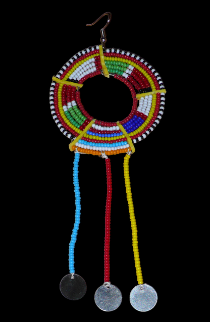Pièce unique composée de perles de rocaille rouges et multicolores, cette mono boucle d'oreille à franges, confectionnée au Kenya dans la plus pure tradition Massai, est un bijou à porter d'un seul côté, qui apportera à votre look une touche éclatante d'asymétrie visuelle. Surdimensionnée, cette mono boucle au style exotique mesure 16 cm de long et 6 cm de large, et se porte avec un crochet en acier inoxydable sur une oreille percée.