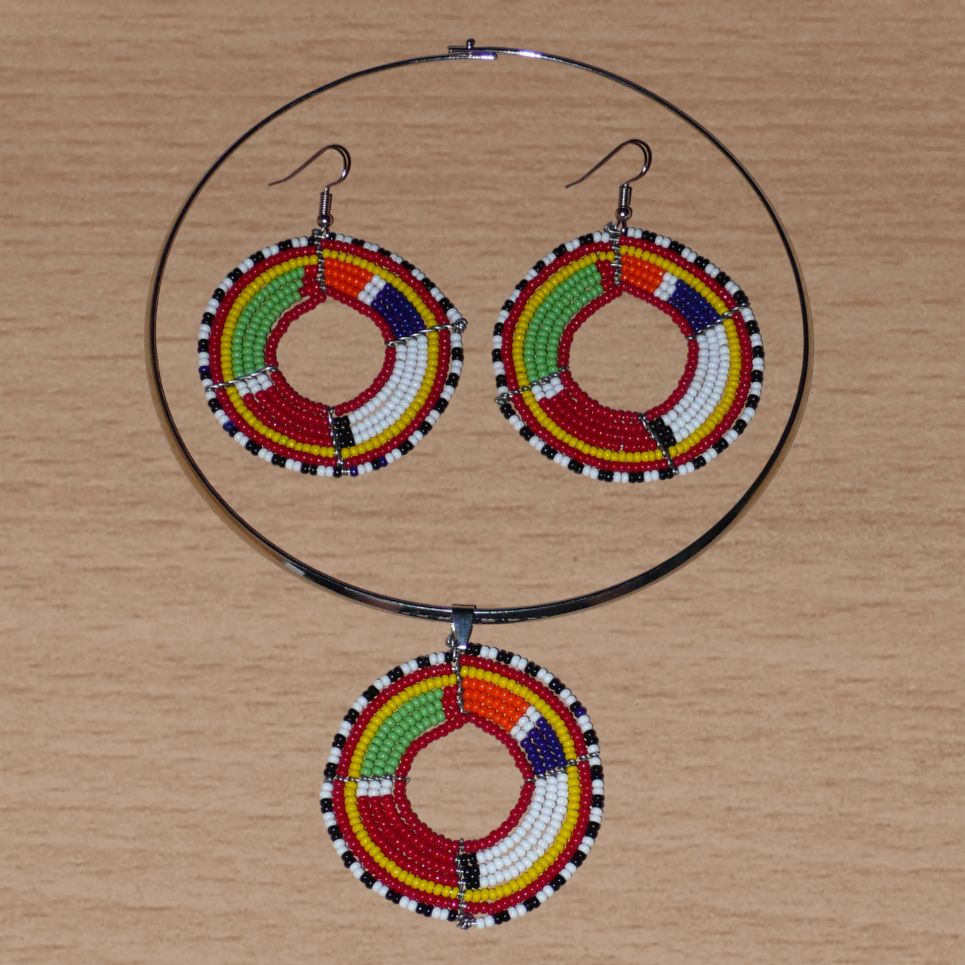 Parure de bijoux ethniques chic composée d'un collier ras-de-cou agrémenté d'un médaillon Massai en perles de rocaille rouges et multicolores, et d'une paire de créoles perlées assorties au collier.