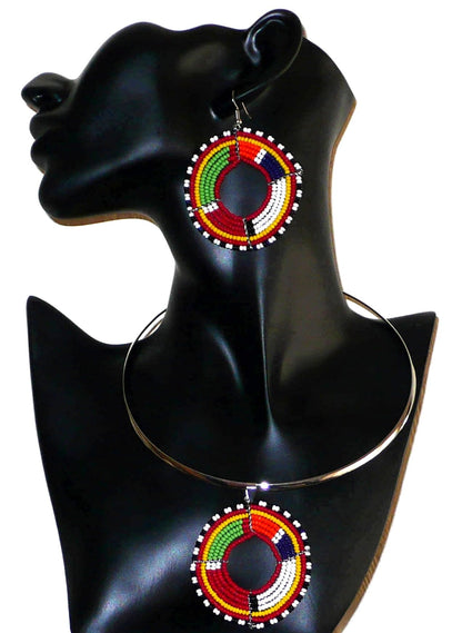 Parure de bijoux au style afro chic des années 70 composée d'un collier ras-de-cou rehaussé d'un médaillon en perles de rocaille rouges et multicolores, et d'une paire de créoles perlées assorties au médaillon du collier. La parure est ici présentée sur un mannequin. Timeless Fineries