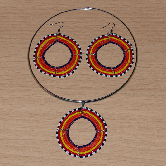Parure de bijoux ethniques principalement orange comprenant un collier ras de cou en laiton orné d'un large médaillon fait de perles de rocaille, et une paire de boucles d'oreilles assorties.