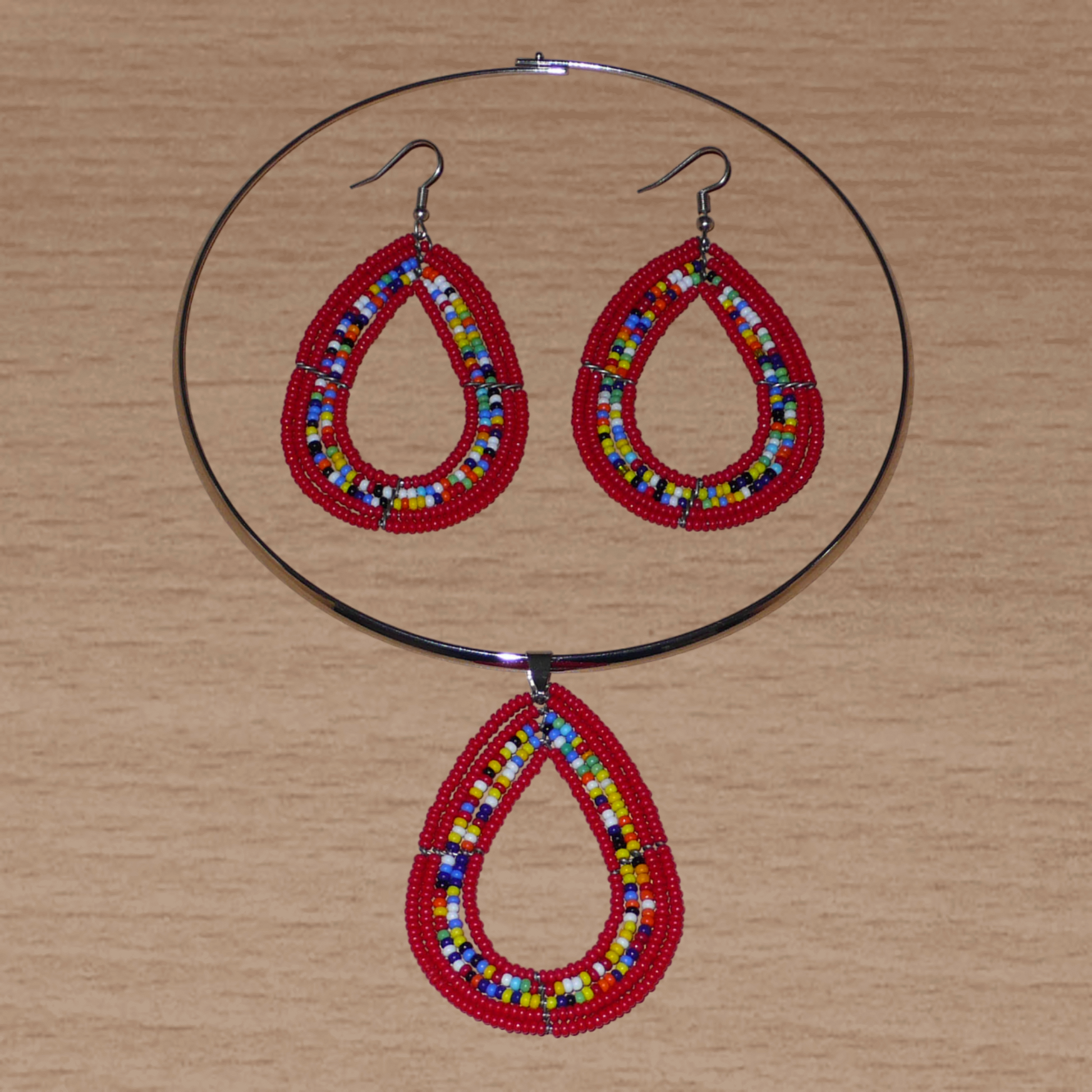 Parure de bijoux ethniques composée d'un collier ras-de-cou orné d'un pendentif en forme de goutte fait de perles de rocaille rouges et multicolores, et d'une paire de boucles d'oreilles assorties.