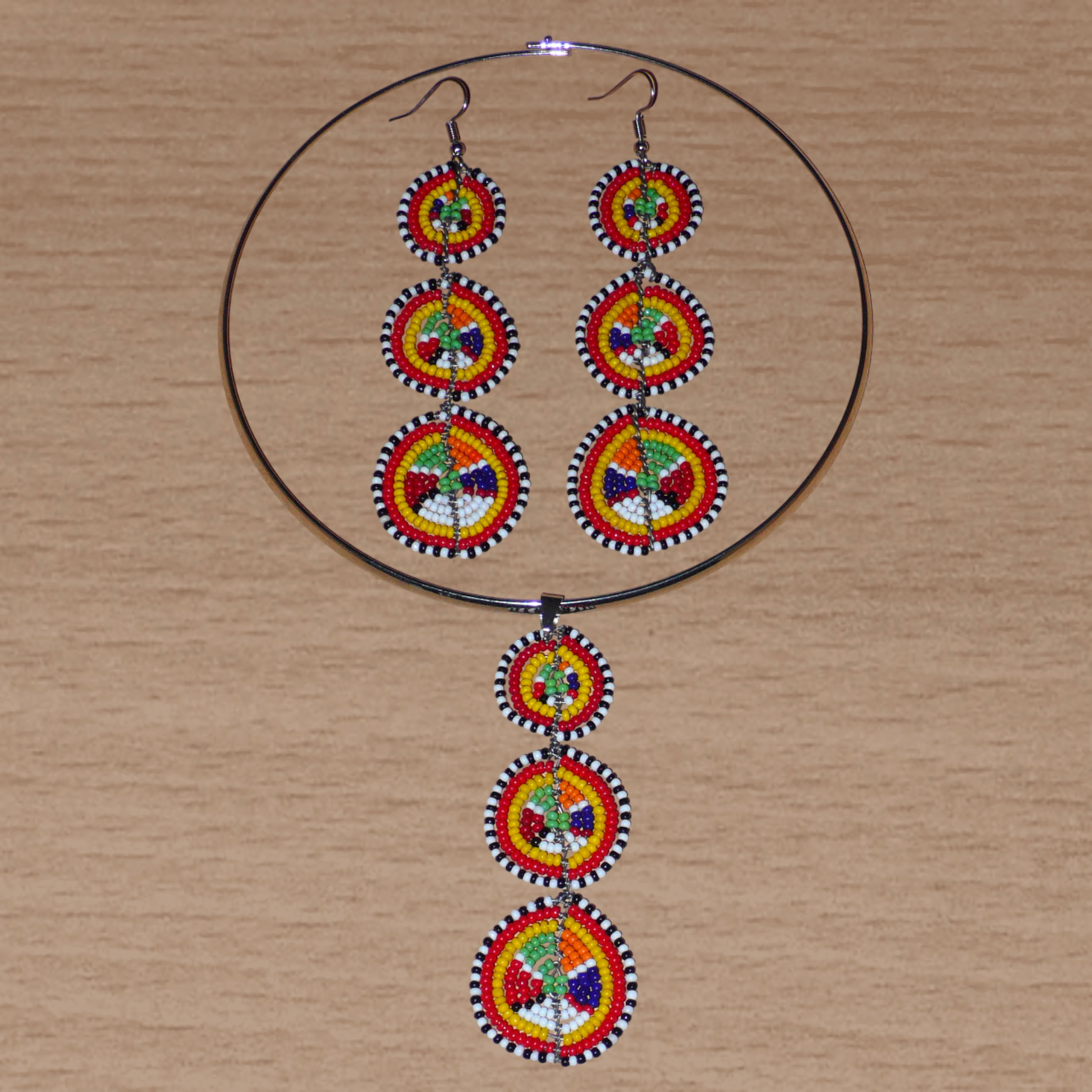 Le style ethnique afro chic des années 70 est à l'honneur avec cette parure de bijoux africains Massai aux accents exotiques ! Elle se compose d'un collier ras de cou agrémenté d'un long pendentif fait de perles de rocaille multicolores façonnées en cercles superposés, et d'une paire de boucles d'oreilles assorties.