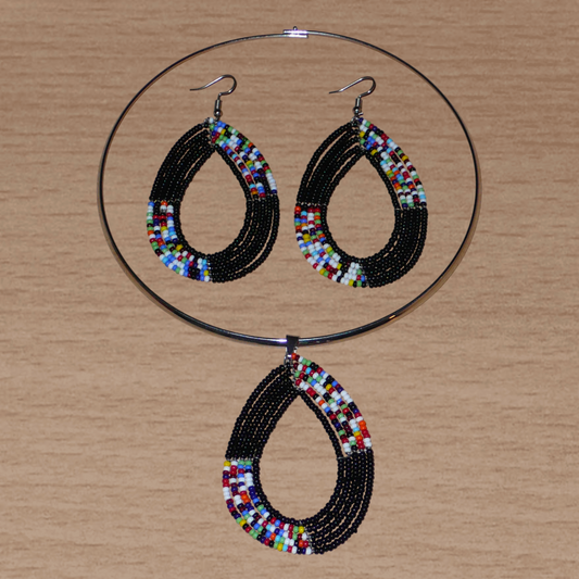 Parure de bijoux ethniques noirs et multicolores composée d'un collier ras de cou en laiton orné d'un long pendentif en forme de goutte fait de perles de rocaille, et d'une paire de boucles d'oreilles assorties.