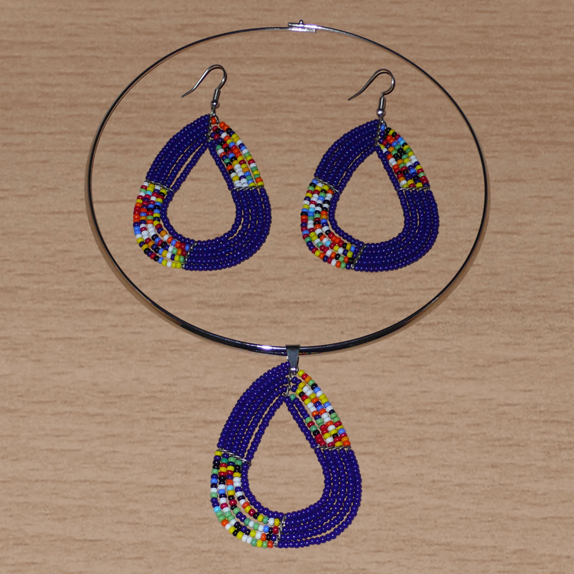 Parure de bijoux ethniques bleus et multicolores composée d'un collier ras de cou en laiton orné d'un pendentif fait de perles de rocaille, et d'une paire de boucles d'oreilles assorties.
