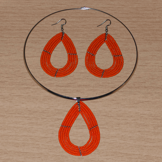 Parure de bijoux orange composée d'un collier ras de cou en laiton orné d'un pendentif en forme de goutte fait de perles de rocaille, et d'une paire de boucles d'oreilles assorties.