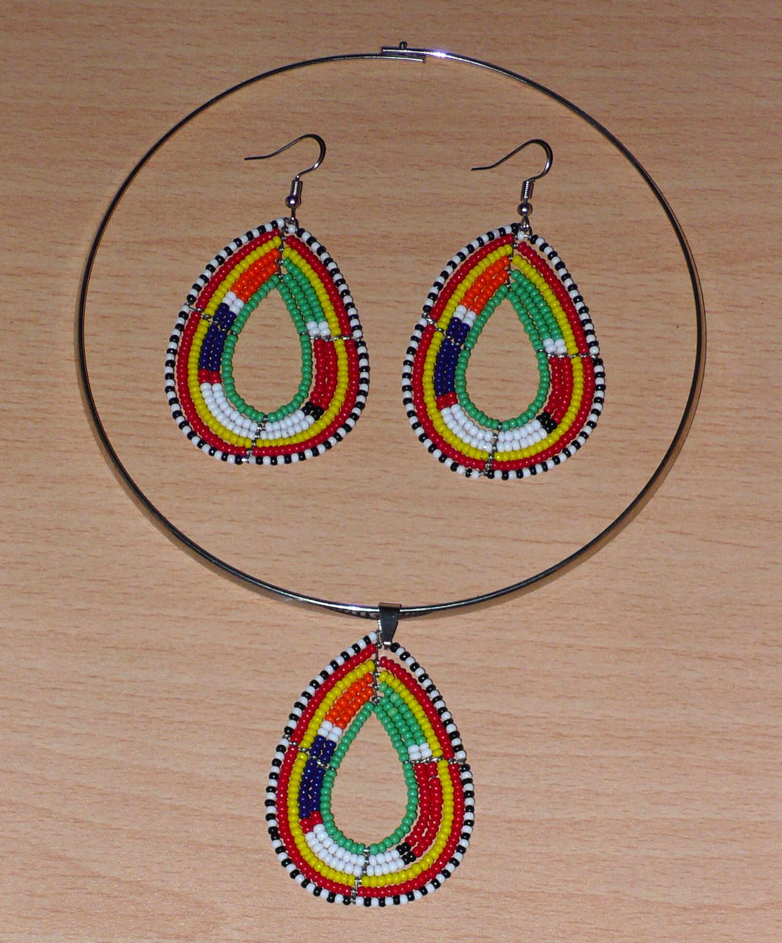 Parure de bijoux africains à motifs ethniques Massai composée d'un collier ras-de-cou orné d'un pendentif en forme de goutte, et d'une paire de boucles d'oreilles assorties faites de perles de rocaille vertes et multicolores.