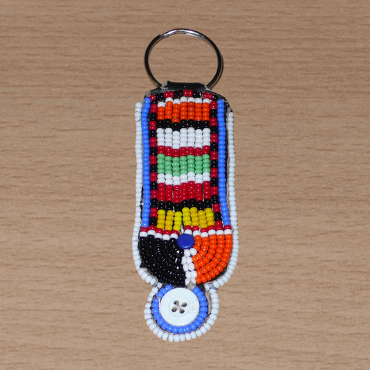 Porte-clés africain à motifs traditionnels Massai composé de perles de rocaille multicolores et de boutons brodés sur un morceau de cuir. Ce porte-clés, brodé sur les deux faces, mesure 10,5 cm de long et 3 cm de large.