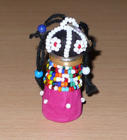 Porte-clés africain en forme de poupée Ndebele fabriqué avec du tissu en coton rose et noir, de la laine, de l'acier, et des perles de rocaille et de plastique multicolores.