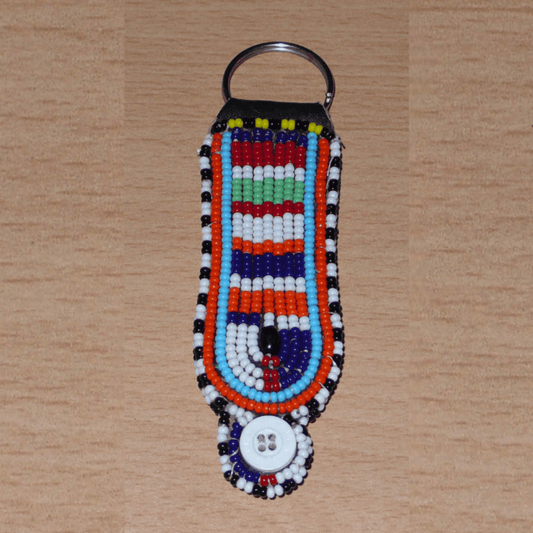 Porte-clés africain Massai composé de perles de rocaille multicolores et de boutons brodés sur un morceau de cuir. Ce porte-clés, brodé sur les deux faces, mesure 10,5 cm de long et 3 cm de large.