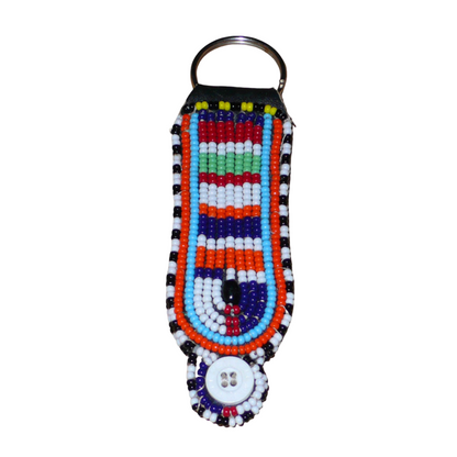 Porte-clés africain Massai composé de perles de rocaille multicolores et de boutons brodés sur un morceau de cuir. Ce porte-clés, brodé sur les deux faces, mesure 10,5 cm de long et 3 cm de large.