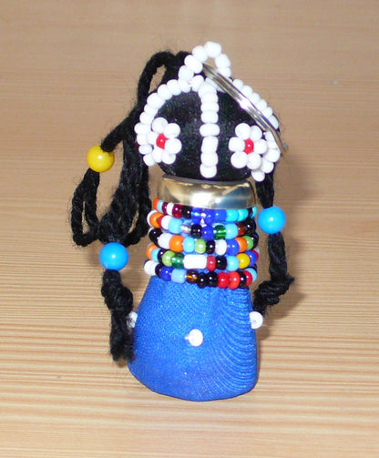 Porte-clés sud-africain en forme de poupée tribale Ndebele composé de tissu en coton bleu et noir, de laine, de laiton, et de perles multicolores.