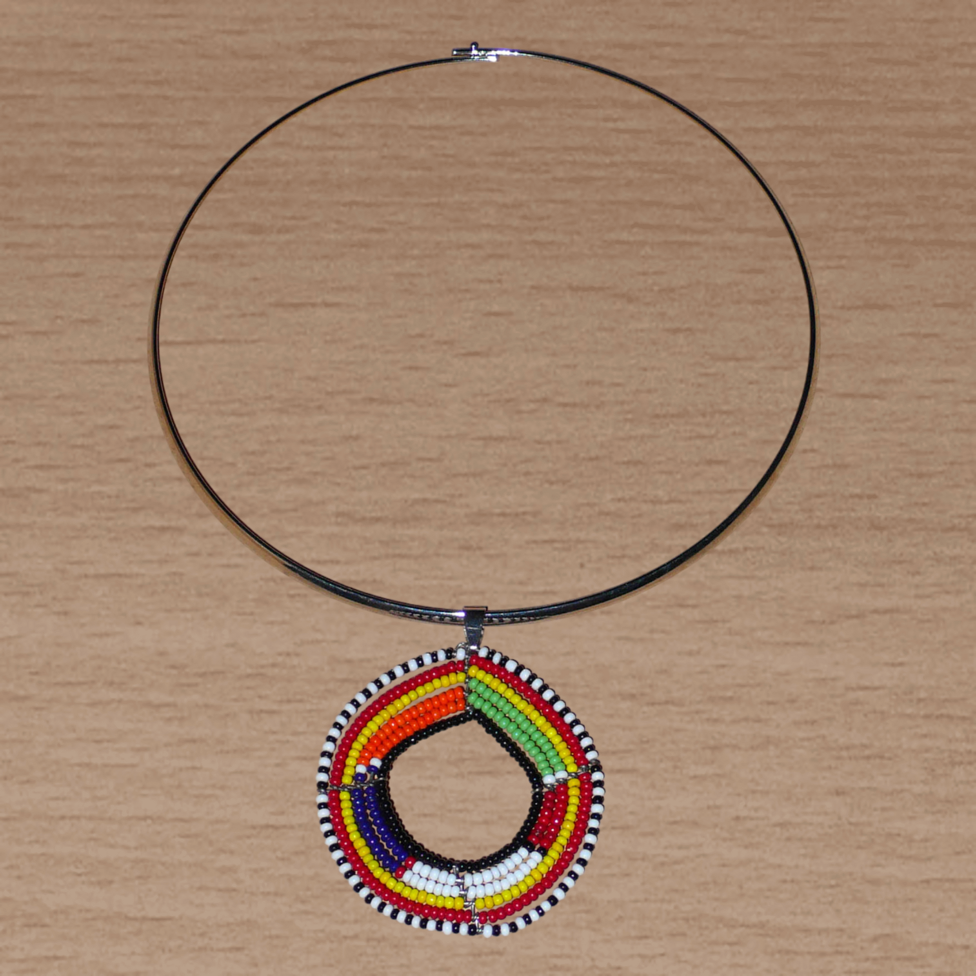 Bijou africain composé d'un collier ras de cou en laiton orné d'un pendentif aux motifs et couleurs Massai en perles de rocaille.