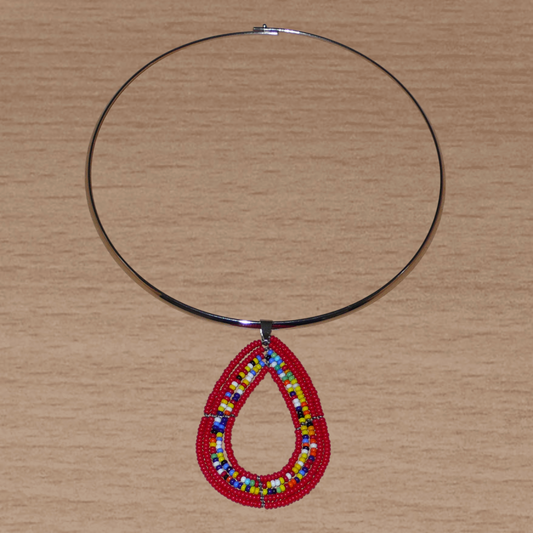 Bijou ethnique rouge composé d'un collier ras de cou en laiton rehaussé d'un pendentif Massai en forme de goutte fait de perles de rocaille rouges et multicolores.