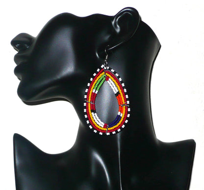 Longues boucles d'oreilles africaines traditionnelles à motifs ethniques Massai. Elles sont faites de perles de rocaille multicolores enfilées sur cinq brins de fils de fer montés en forme de gouttes. Ces boucles d'oreilles mesurent 8,5 cm de long et 4,4 cm de large. Elles se portent sur des oreilles percées.