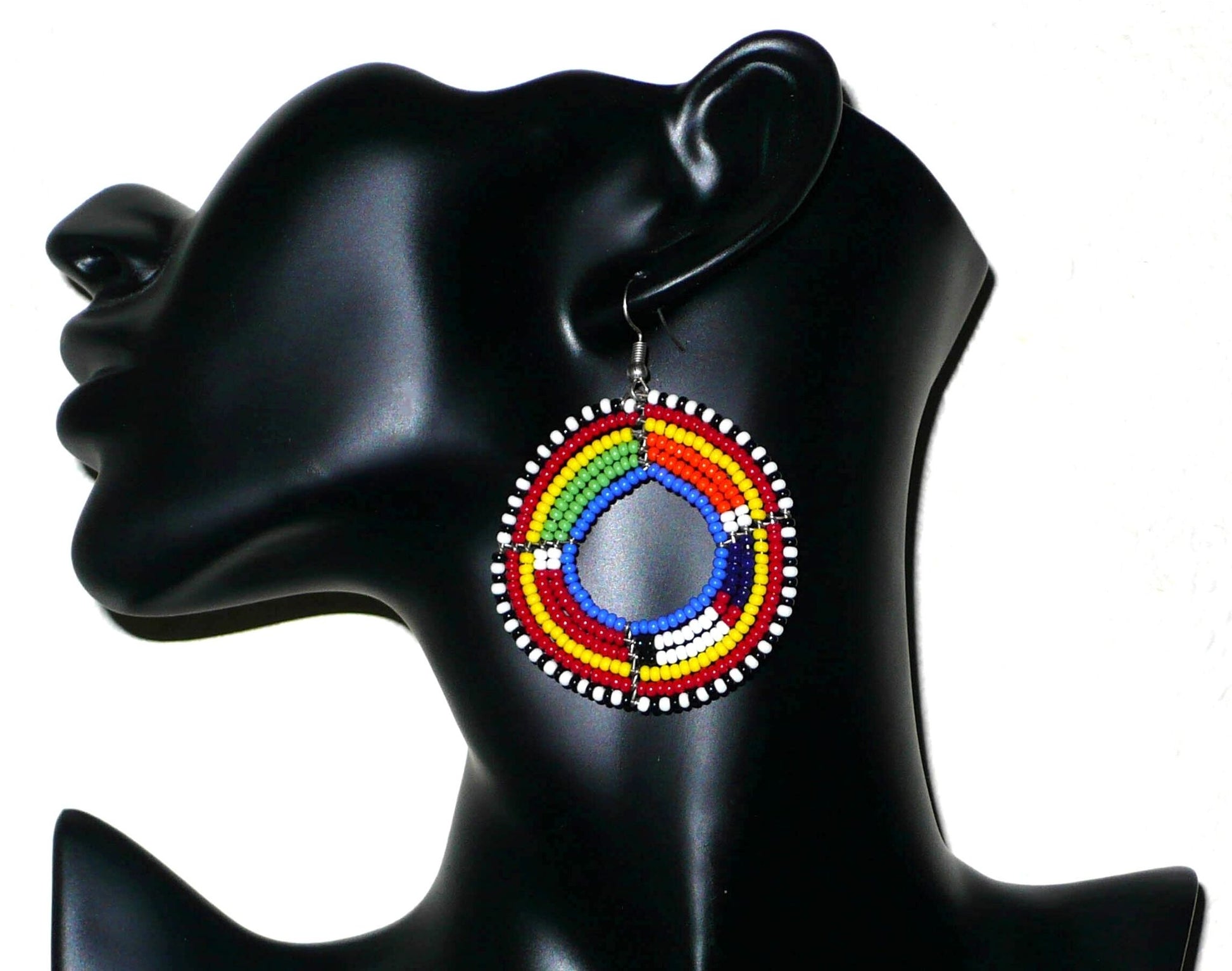 Boucles d'oreilles africaines rondes à motifs traditionnels Massai. Elles se composent de perles de rocaille bleues et multicolores enfilées sur six brins de fils de fer montés en forme de cercles. De taille moyenne, ces boucles d'oreilles mesurent 7 cm de long et 5 cm de large. Timeless Fineries