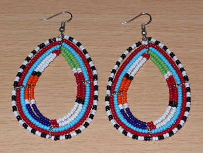 Boucles d'oreilles africaines à motifs ethniques Massai faites de perles de rocaille multicolores montées en forme de gouttes. Elles mesurent 8,5 cm de long et 4,5 cm de large et se portent sur des oreilles percées.