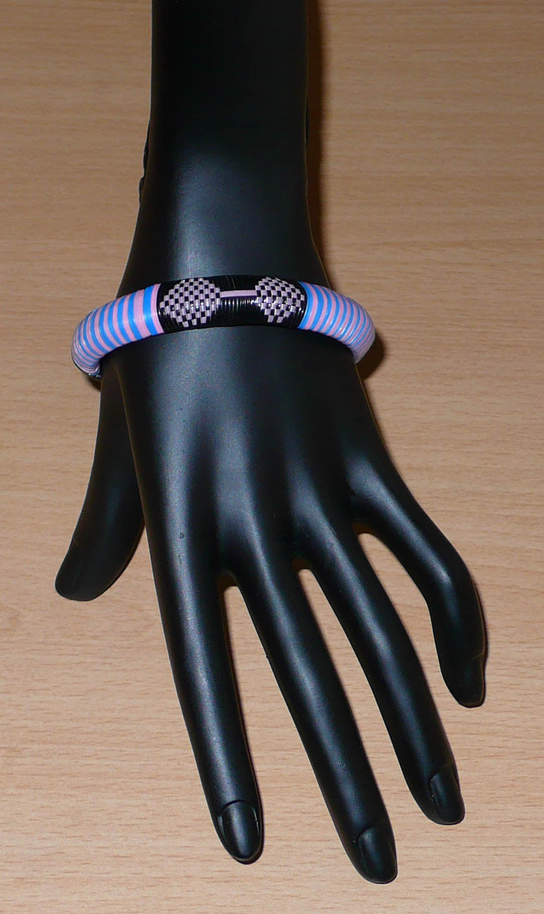 Bracelet africain eco-friendly à motifs ethniques tressés avec de fines bandes de plastique recyclé noir, rose et bleu. 