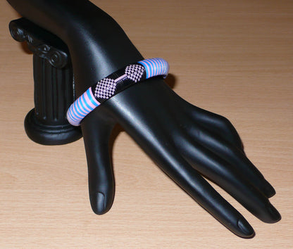 Bracelet africain eco-friendly à motifs ethniques tressés avec de fines bandes de plastique recyclé noir, rose et bleu.