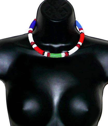 Bijou africain traditionnel. Collier africain tubulaire à motifs ethniques Massai fait de perles de rocaille bleues, blanches, bleues, vertes et rouges enroulées autour d'un tube en plastique. Il mesure 18 cm de long, sa longueur autour du cou est de 45 cm et son épaisseur de 1 cm ; il s'attache avec un crochet. Timeless Fineries