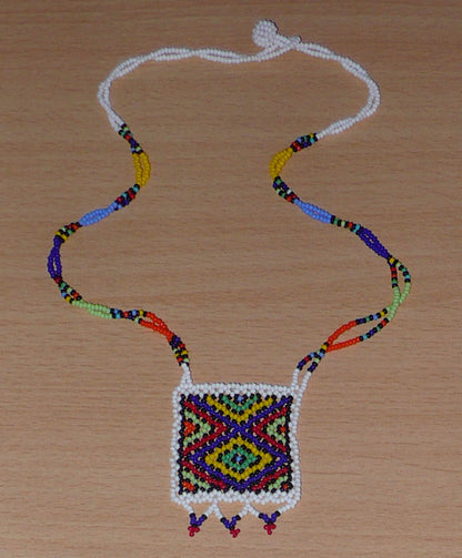 Collier africain zoulou avec pendentif ; fabriqué en Afrique du Sud, il se compose d'un tissage traditionnel de perles de rocaille blanches et multicolores.
