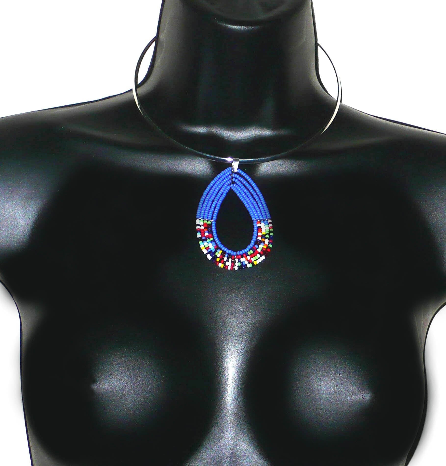 Collier ras de cou en laiton argenté orné d'un long pendentif fait de perles de rocaille bleues et multicolores enfilées sur cinq rangées de fils de fer montés en goutte. Ce collier mesure 21 cm de long, la circonférence du tour de cou en laiton est de 4é,5 cm pour un diamètre de 13,5 cm ; le pendentif perlé mesure 7 cm de long et 4,5 cm de large.