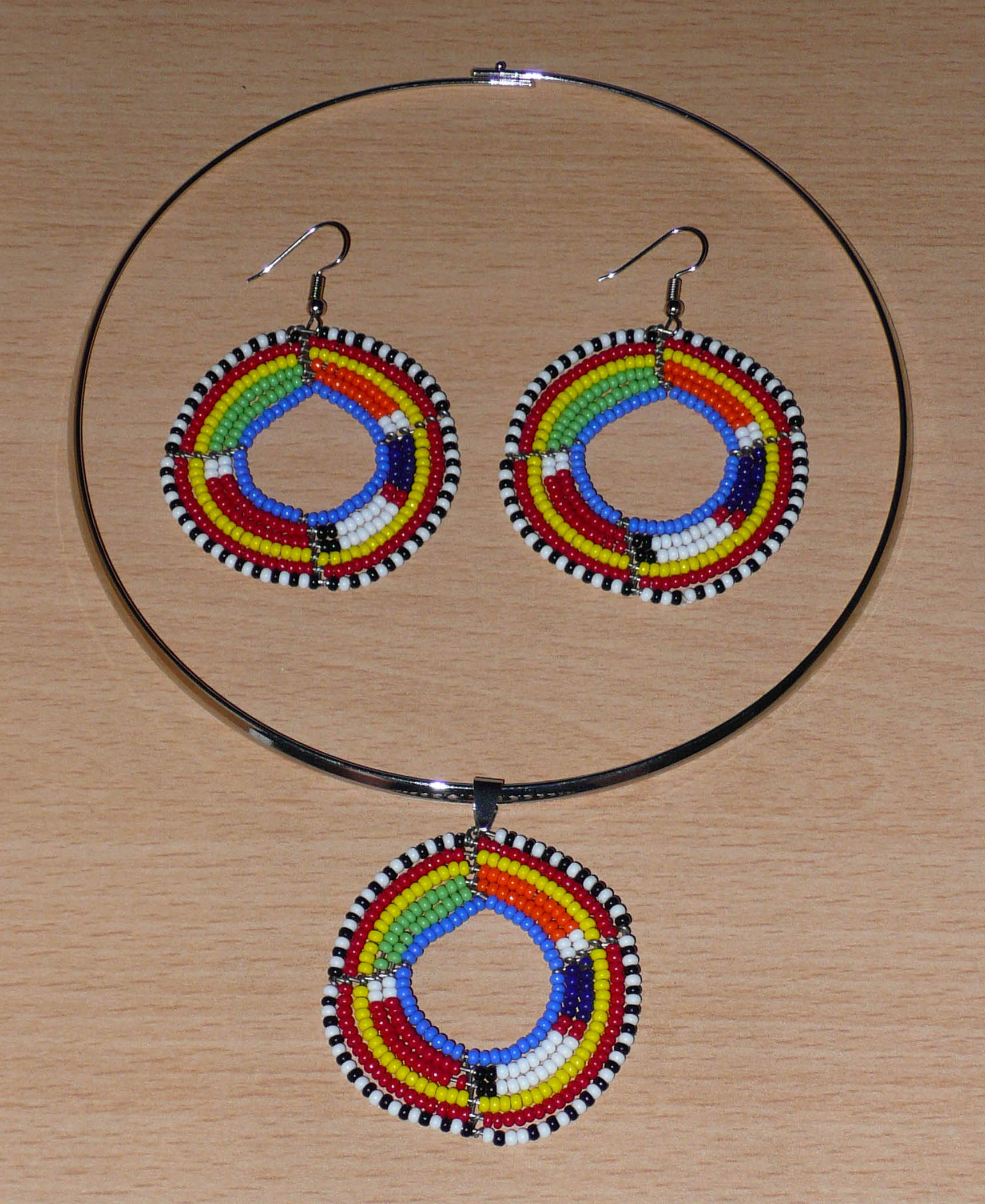 Parure de bijoux africains à motifs et couleurs ethniques Massai comprenant un collier ras-de-cou avec médaillon, et une paire de boucles d'oreilles rondes assorties. Timeless Fineries